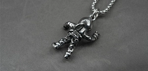 Detailed view of a vintage titanium steel astronaut pendant on a textured grey fabric