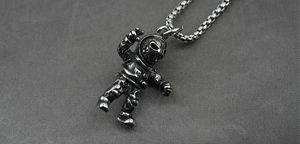 Detail of silver titanium astronaut pendant with vintage texture and pearl box chain