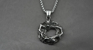 Vue rapprochée du collier en acier titane argenté avec un pendentif rond au motif de dragon