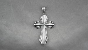Detailed view of the silver cross pendant with radial stripes and textured edges