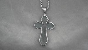 Detailed macro view of the box chain and cross pendant with matte grey inlay texture