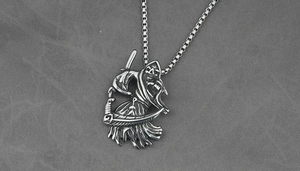 Macro-opname van gotische Magere Hein-hanger met zeis aan een vintage box-ketting