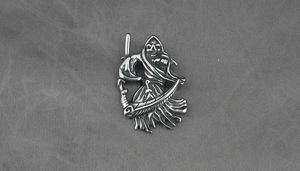 Detailopname van vintage zilveren magere hein hanger met zeis detail en metalen textuur