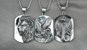 Detail von Löwen-, Adler- und Schlangen-Reliefanhängern an Vintage-Stahlketten