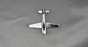 Détail du pendentif avion en argent avec finition acier poli sur tissu gris