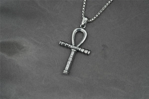 Detail eines Vintage-Ankh-Anhängers aus Stahl mit Horusauge-Gravur und Perlenkette