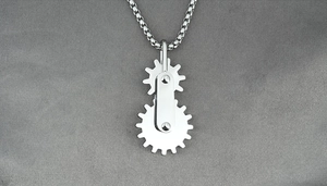 Macro detail of industrial style double gear pendant with mechanical silver finish