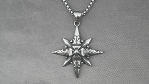 Close-up of vintage stainless steel star pendant with compass texture and box chain