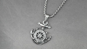 Detailed macro view of anchor and helm pendant with sparkling rhinestones on box chain