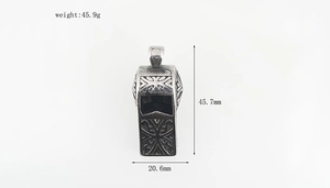 Macro view of vintage silver whistle pendant with tribal patterns and detailed dimensions
