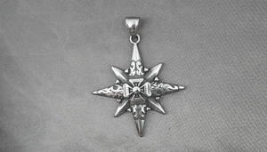Close-up of vintage titanium steel star pendant with gothic cross engraving and aged finish