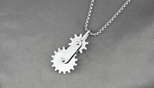 Macro view of mechanical spinning gear necklace pendant with silver metal chain