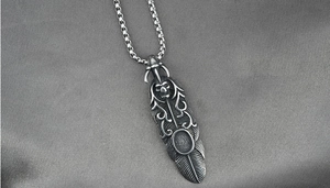 Détail du pendentif gothique en forme de plume et crâne sur collier argenté rétro