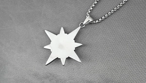 Macro shot of polished octagonal star titanium steel pendant on a silver link chain