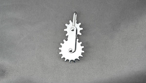 Detailed view of stainless steel dual gear rotating Wartenberg wheel on gray satin cloth