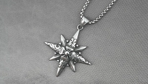 Detailed macro view of an octagonal star compass pendant with vintage steel finish