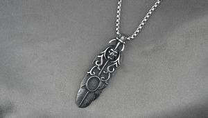 Vue détaillée du pendentif plume en argent vintage avec crâne et motifs de vignes