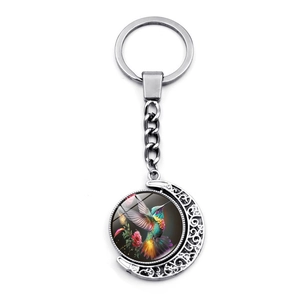 Rotating hummingbird moon pendant keychain made of colorful alloy and glass in white background