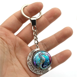 Porte-clés lune rotatif avec pendentif en verre hippocampe coloré sur métal argenté