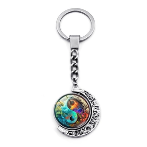 Artistic Yin Yang moon keychain pendant with a rotating silver crescent and forest galaxy design