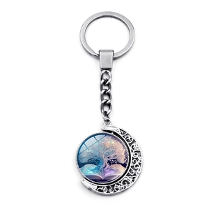 Rotating silver Tree of Life and Glowing Book moon pendant keychain on white background