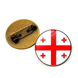 Dettaglio fronte e retro della spilla con bandiera della Georgia in vetro e base in bronzo