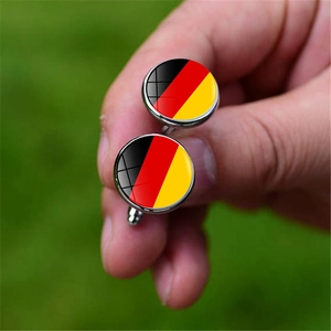 Detail of silver round cufflinks with German flag emblem held by fingers