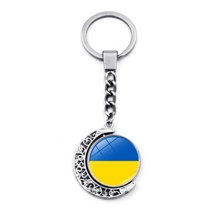Detailed close-up of Ukraine flag rotating moon pendant keychain in silver finish
