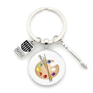 Macro detail of art palette keychain with metal crayons pendant and miniature paintbrush