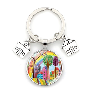 Detail of artistic keychain with rainbow glass dome pendant and silver metal house charms