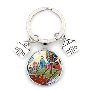 Detail of artistic star night keychain featuring glass cabochon and house charms