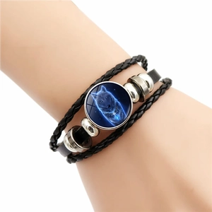 Detail of multi-layer leather braided wolf snap bracelet with blue cosmic wolf head charm