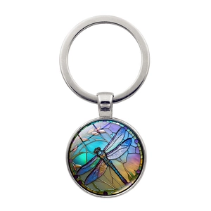 Detailed macro view of a dragonfly glass pendant with vibrant blue and purple wings