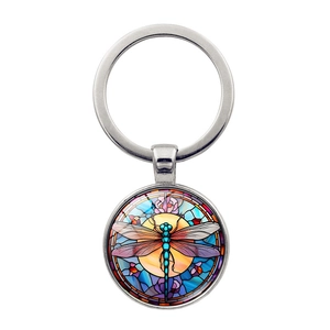 Detailed close-up of a vintage dragonfly glass gem pendant on a metal keychain ring