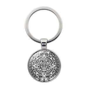 Detailed macro view of Aztec Sun Calendar glass dome pendant with silver metal keyring