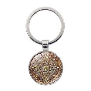 Close-up of the intricate Aztec sun calendar patterns on a silver keychain pendant