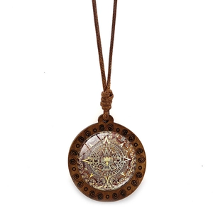 Détail du pendentif rond en bois avec motif calendrier aztèque et cordon tressé vintage