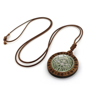 Détail du collier calendrier aztèque en bois avec textures spirales et cordon marron
