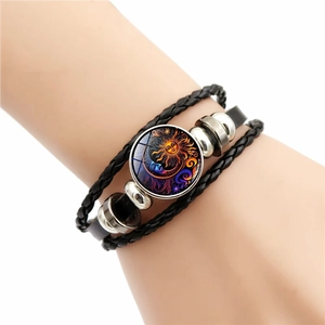 Detail eines mehrlagig geflochtenen Lederarmbands mit einem Glas-Cabochon aus Sonne und Mond