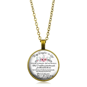 Détail d'un pendentif doré vintage avec dôme en verre et motifs floraux roses