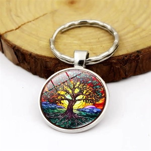 Artistic tree of life keychain with glass dome pendant on natural wooden background