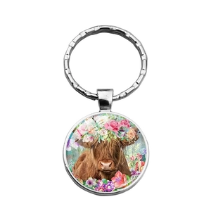 Artistic Highland Cow keychain with floral wreath pendant in silver metal ring