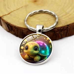 Cute sea turtle glass gem keychain with silver metal ring on a wooden surface