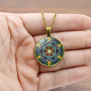 Détail d'un collier pendentif mandala en bronze vintage avec cabochon en verre coloré