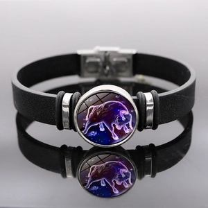 Dettaglio bottone zodiaco Toro su bracciale in pelle nera con cupola in vetro stellato