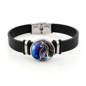Dettaglio macro del segno zodiacale Capricorno su un bracciale in pelle intrecciata nera