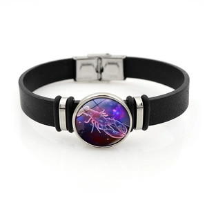 Vista dettagliata del bracciale in pelle nera con ciondolo luminoso del segno del Cancro