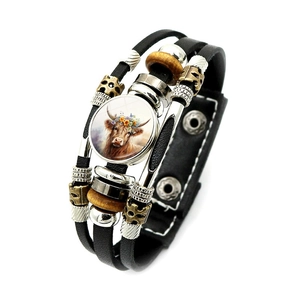 Dettaglio macro del bracciale in pelle multistrato con charm in vetro di mucca e perline