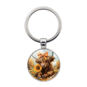 Close-up of highland cow with sunflower illustration in a silver glass pendant keychain