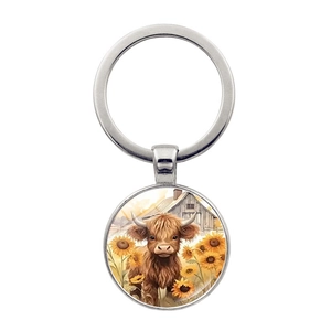 Silver highland cow keychain with sunflower glass dome pendant on white background